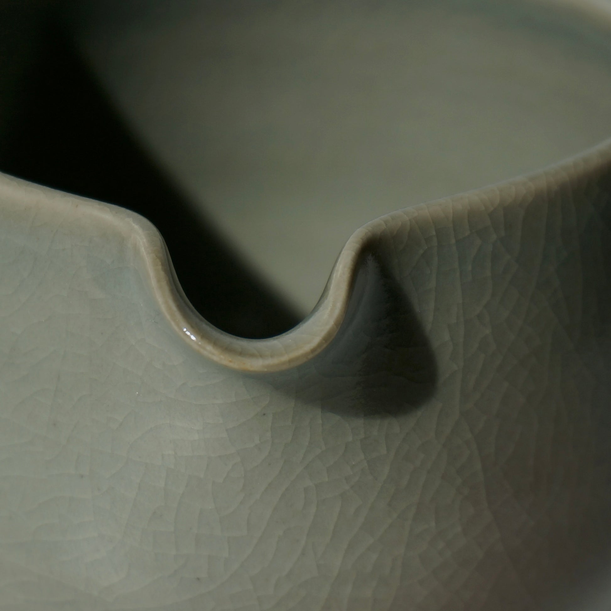 close up of handmade ceramic spouted matcha bowl with green crackled celadon glaze