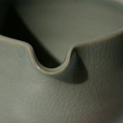 close up of handmade ceramic spouted matcha bowl with green crackled celadon glaze