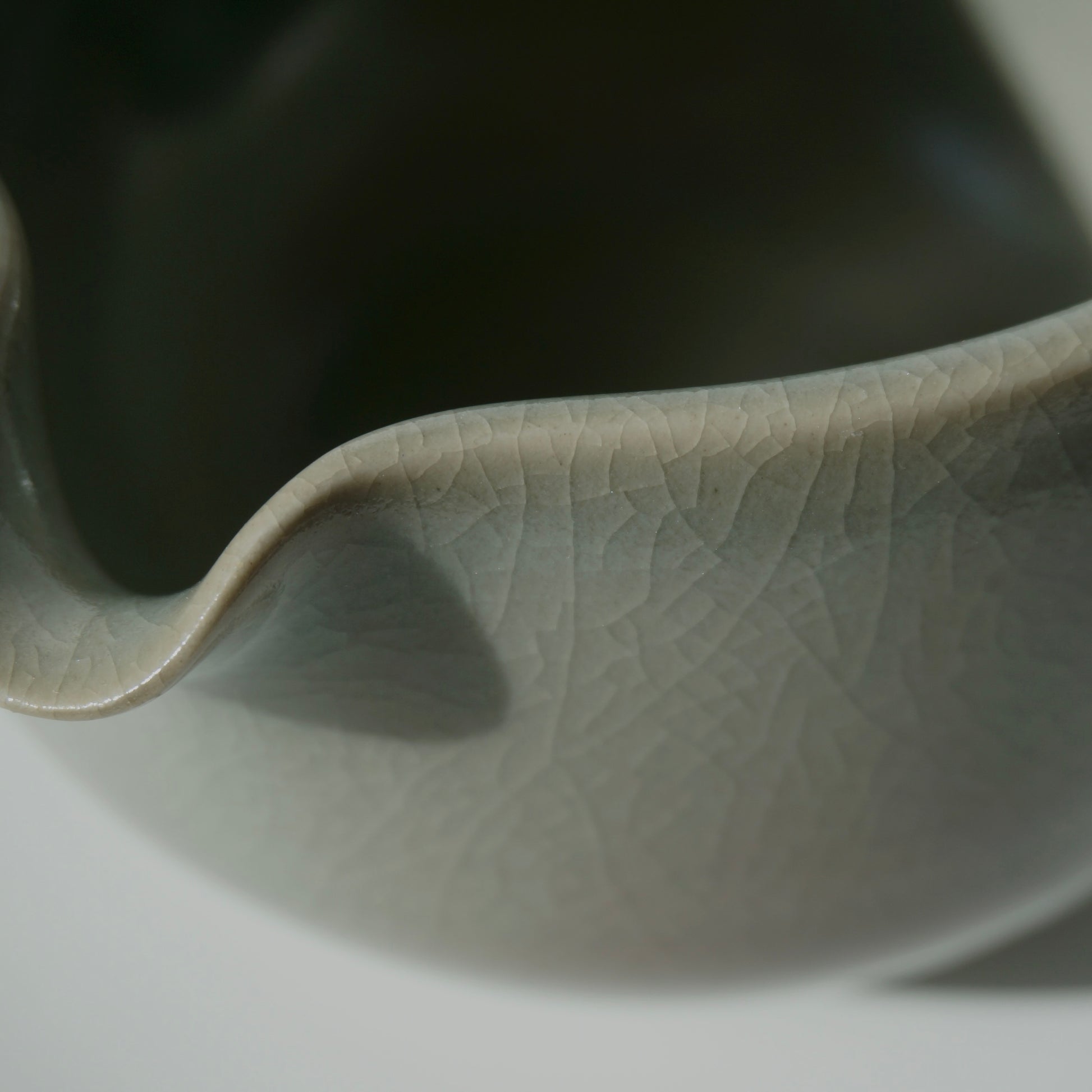 close up of handmade ceramic spouted matcha bowl with green crackled celadon glaze