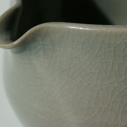 close up of handmade ceramic spouted matcha bowl with green crackled celadon glaze