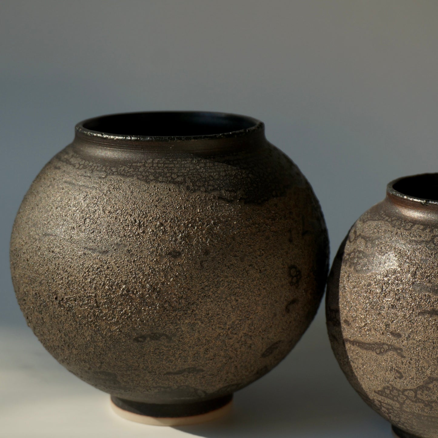 Two black textured handmade ceramic moon jars by Kongji Pottery