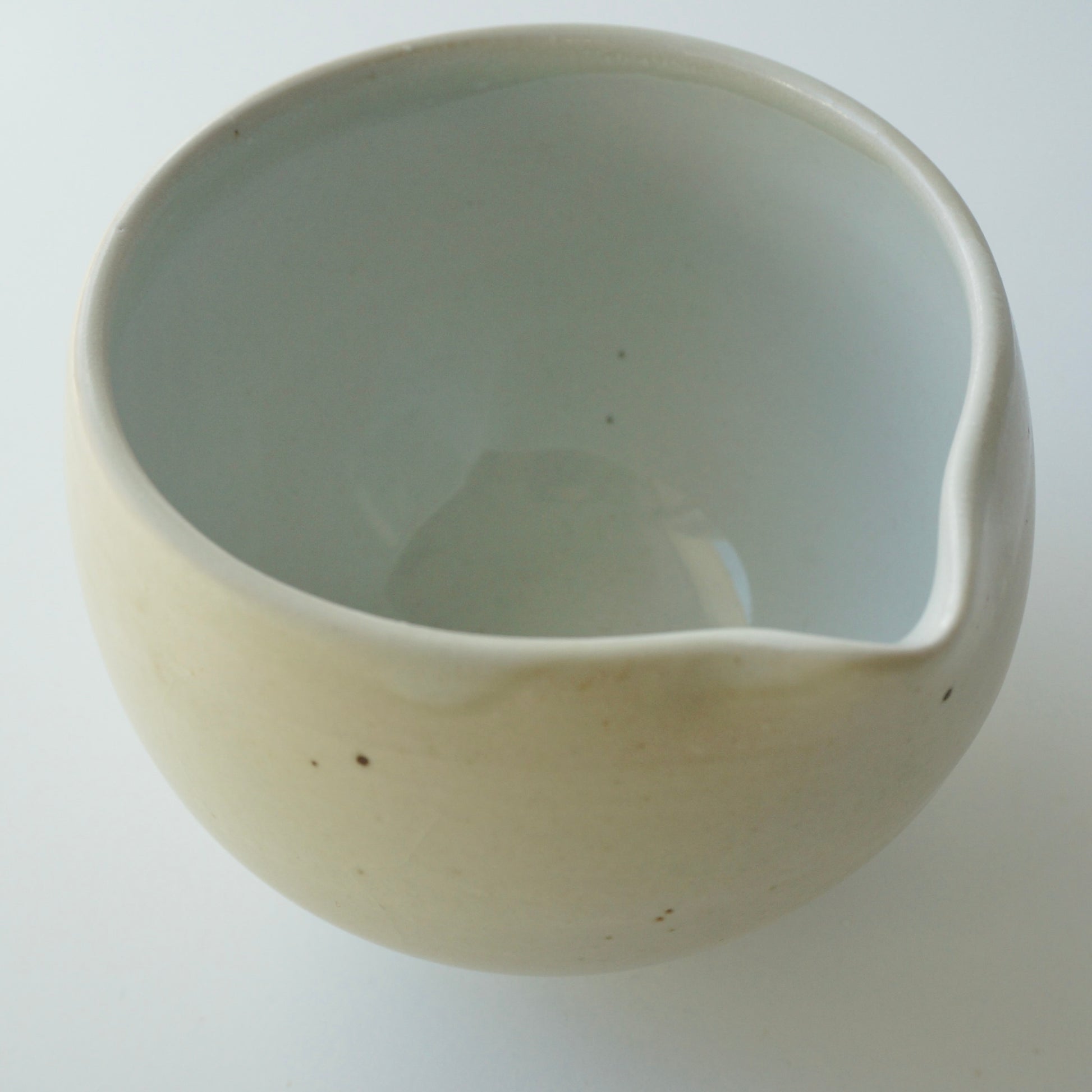 Handmade wheel thrown ceramic spouted matcha bowl in matte and glossy white. Made by Kongji Pottery.