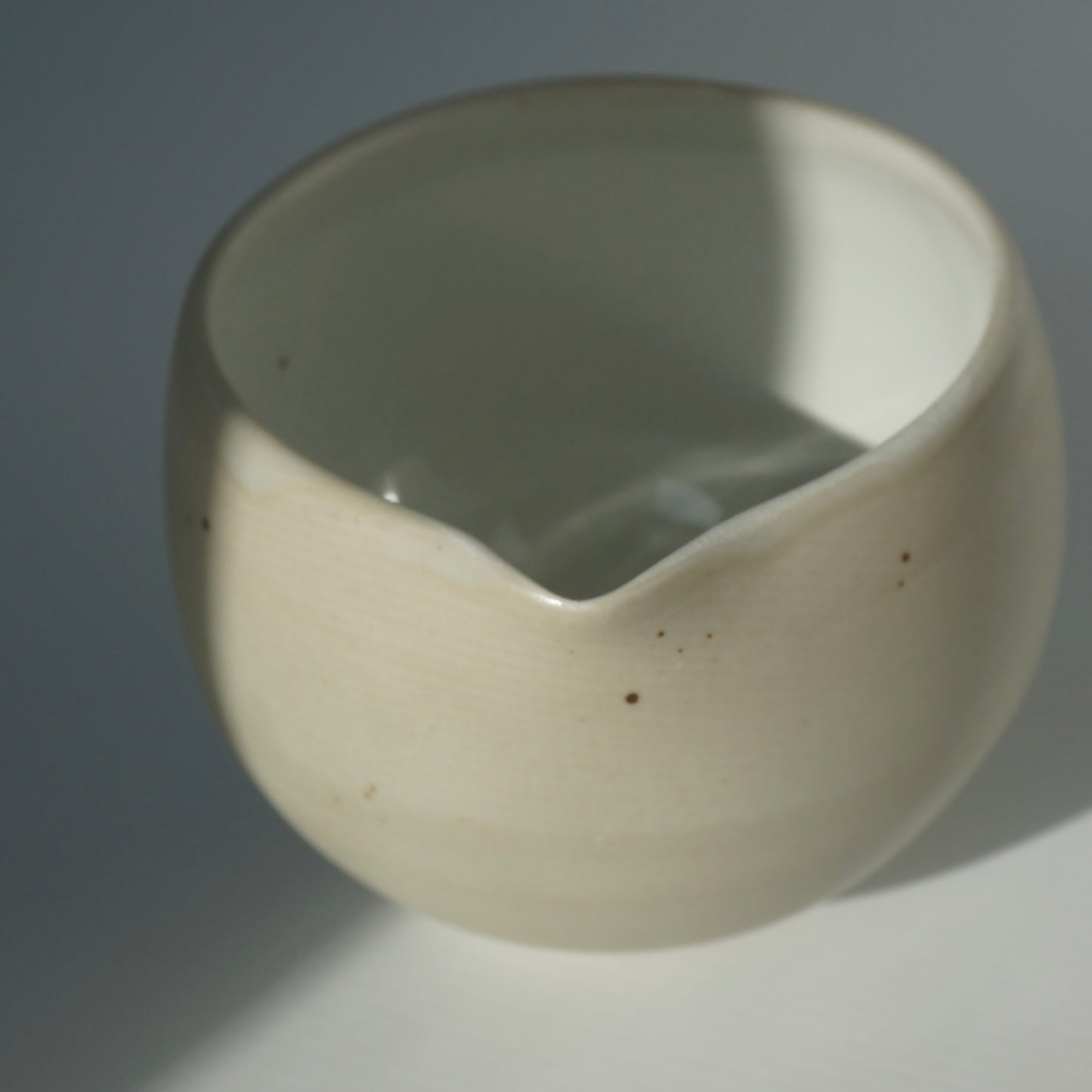 Handmade wheel thrown ceramic spouted matcha bowl in matte and glossy white. Made by Kongji Pottery.