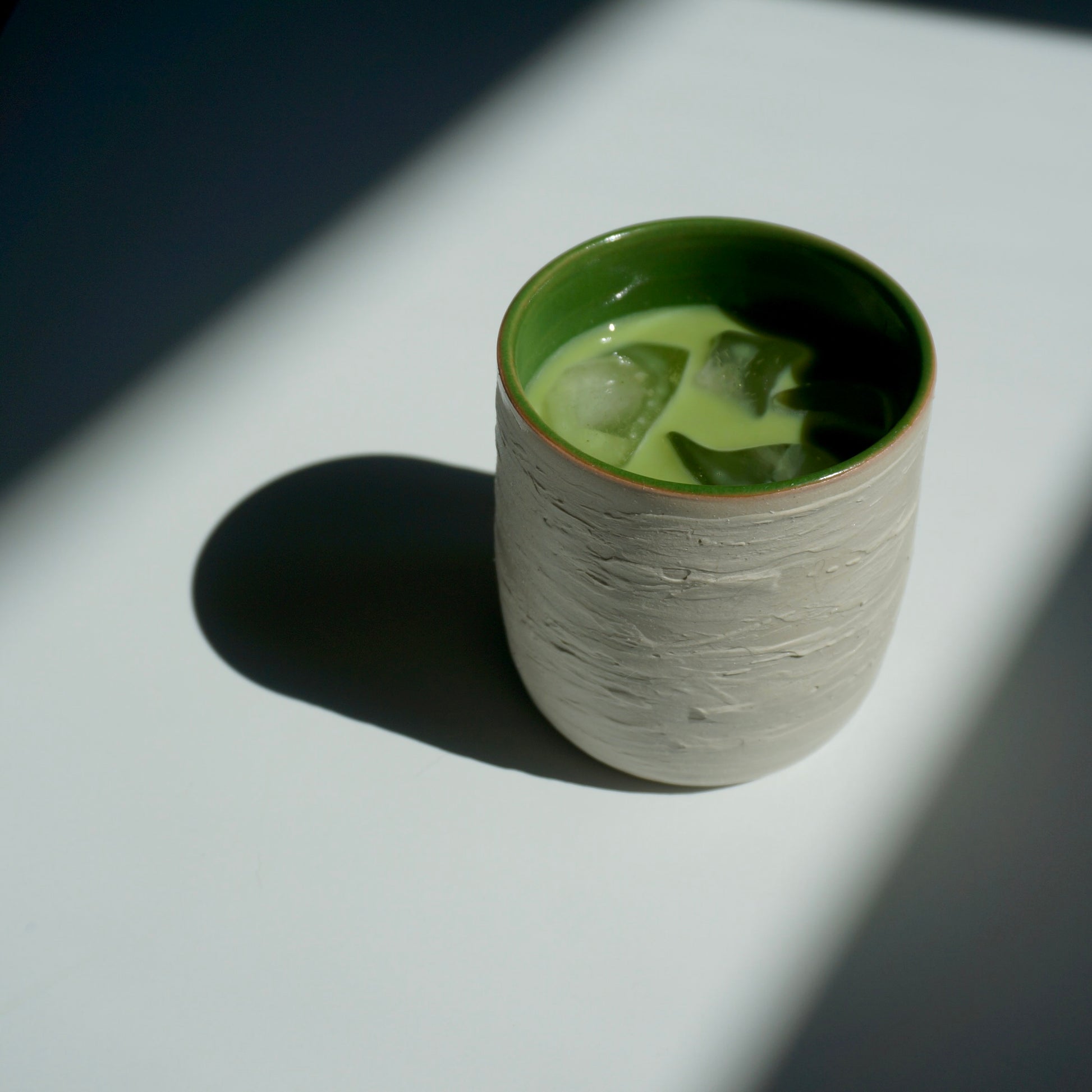 handmade ceramic cup with green interior and textured exterior by Kongji Pottery