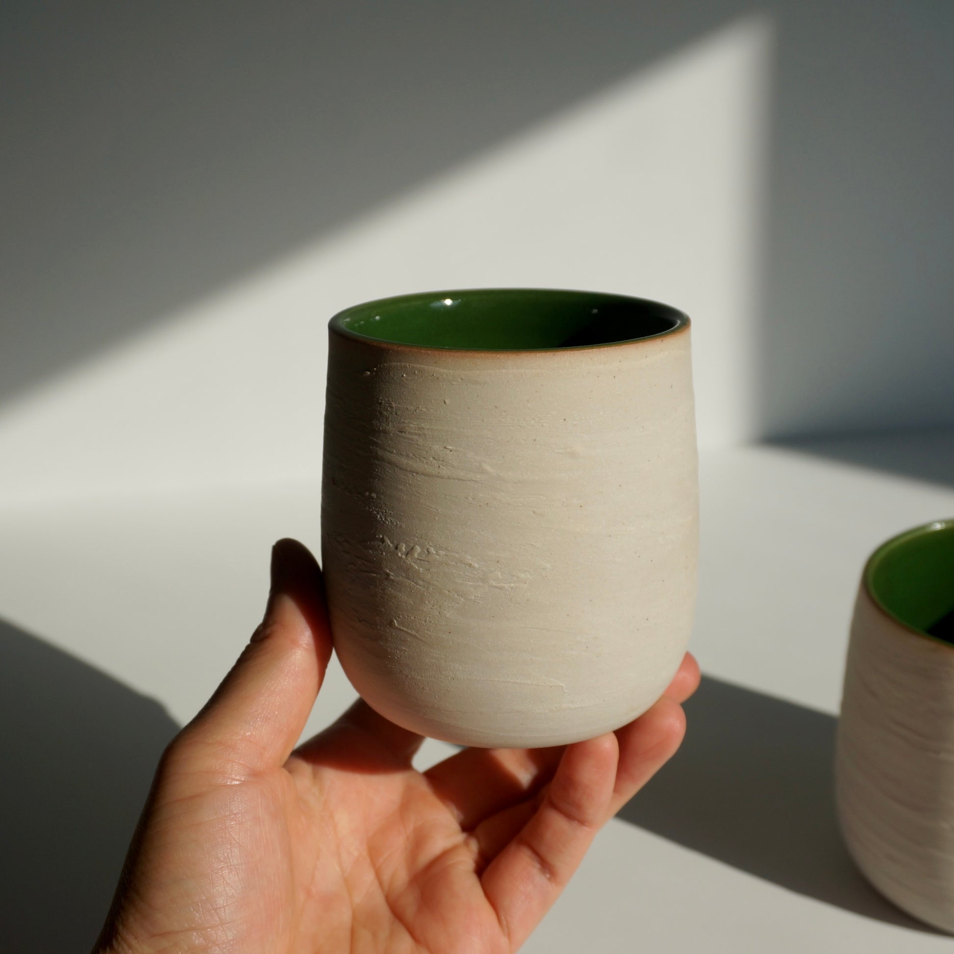 handmade ceramic cup with green interior and textured exterior by Kongji Pottery