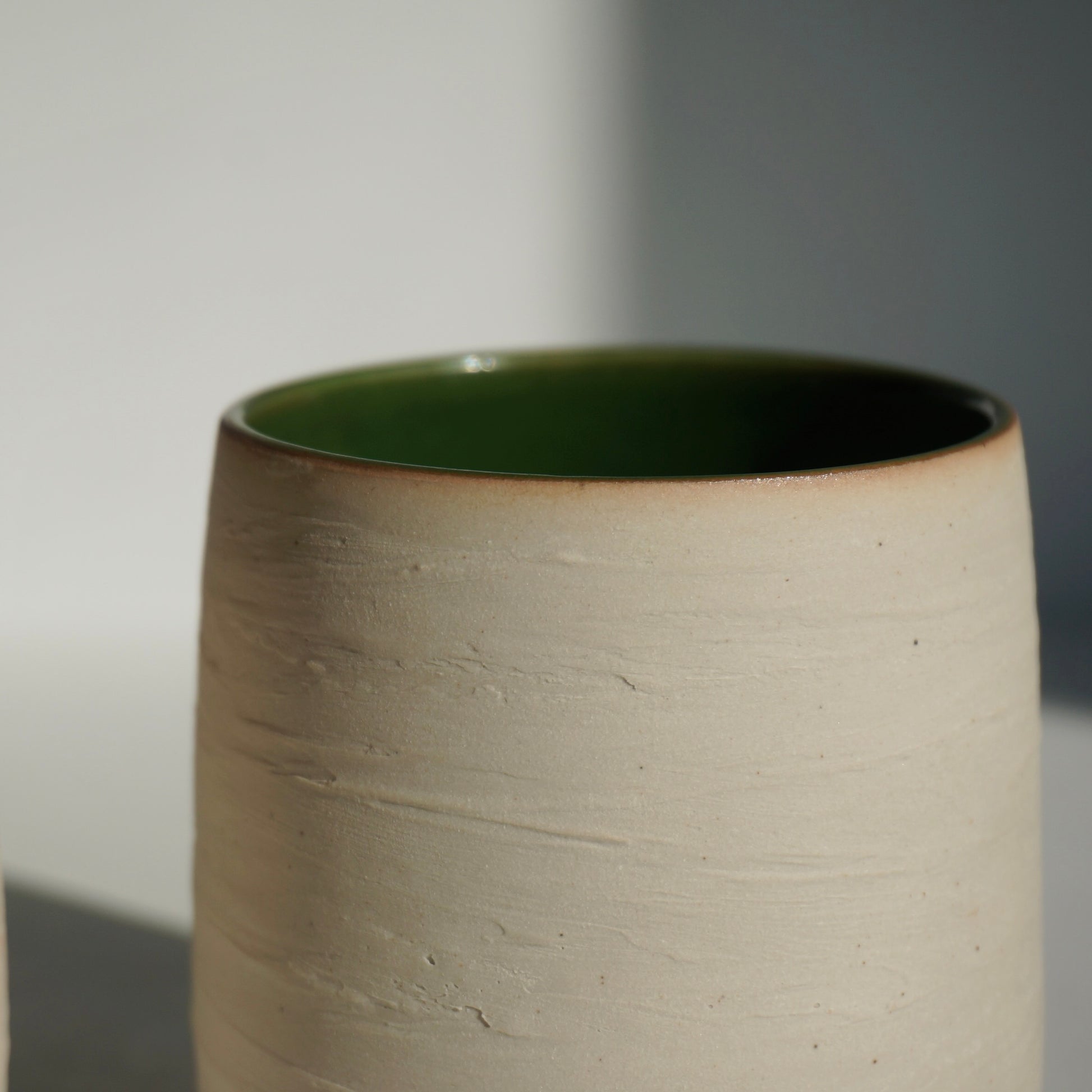 handmade ceramic cup with green interior and textured exterior by Kongji Pottery